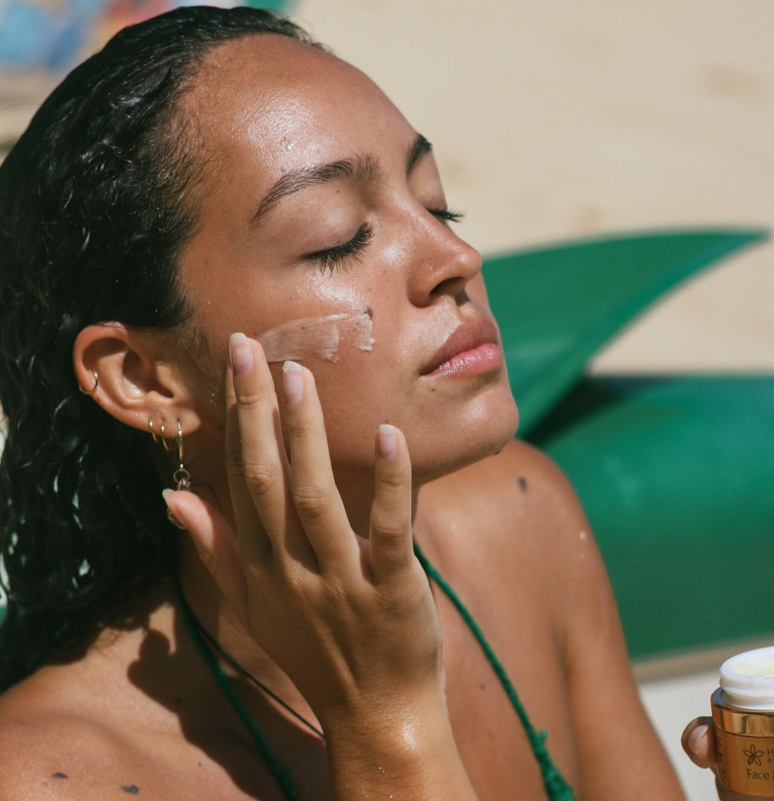 Woman applying Face & Eye Crème on her face with a blurred background